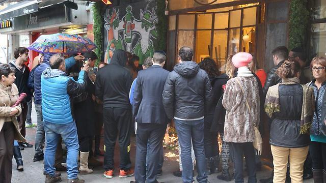 People gather to light candles at the scene of the terror attack (Photo: Motti Kimchi)