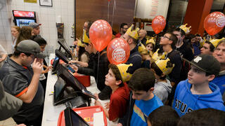 Children wearing paper crowns wait in line at the counter during the opening of Burger King’s first branch in Israel, in Tel Aviv, Feb. 2016 