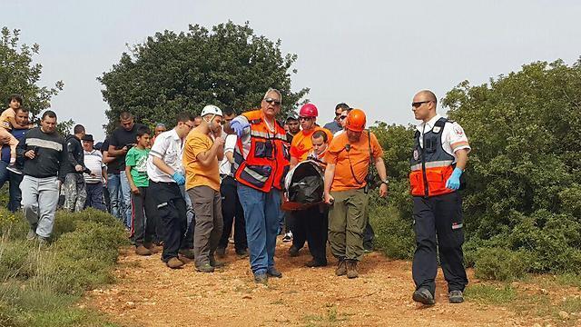 Search and rescue teams carry BG Amar's body from the scene