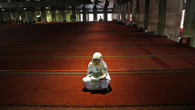A girl praying in Jakarta, Indonesia. (Photo: AP) (צילום: AP) A girl praying in Jakarta, Indonesia. (Photo: AP)