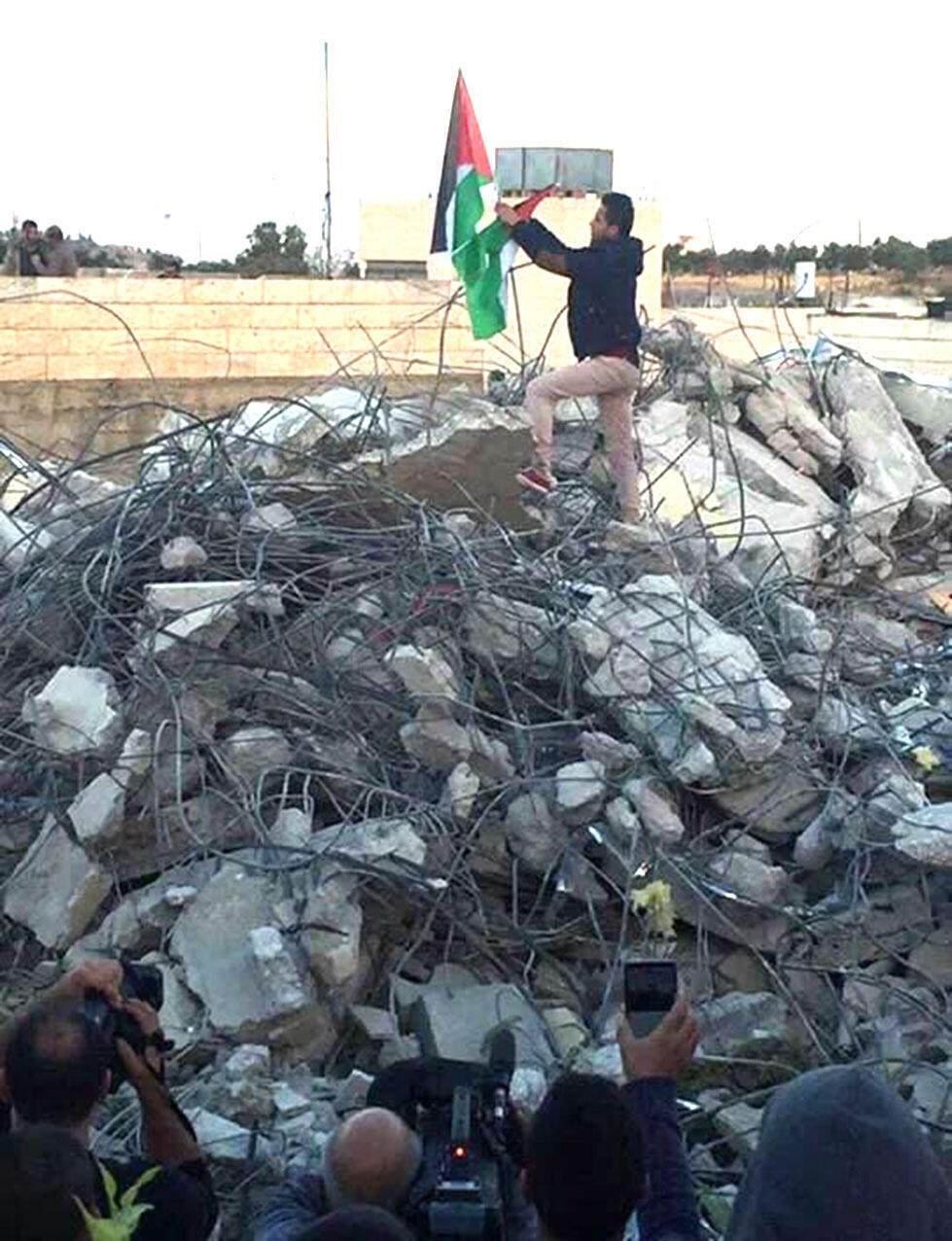 The Palestinian flag on the demolished home.