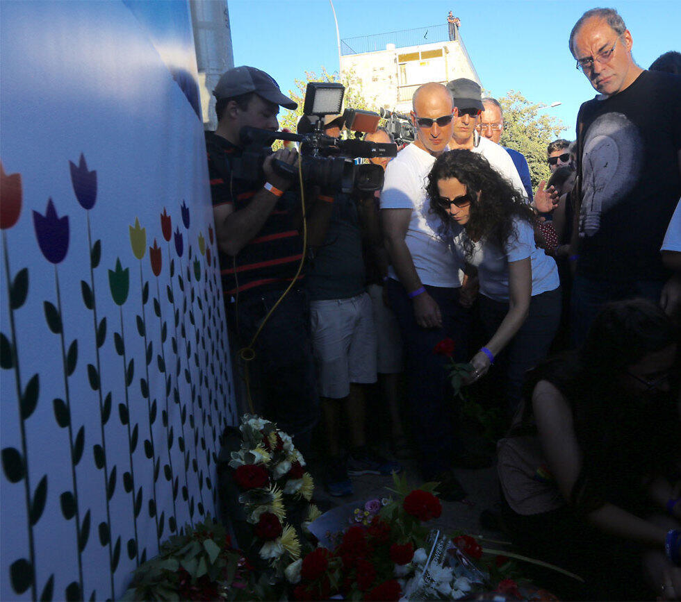 Shira Banki's mother, 2016 Pride March, lays a flower at the site where her daughter was stabbed (Photo: Gil Yohanan)