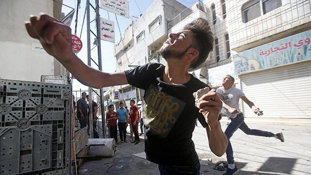 Palestinian youth throwing stones at IDF forces (Photo: EPA) (צילום: EPA) Palestinian youth throwing stones at IDF forces (Photo: EPA)