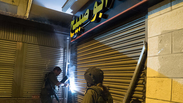 The IDF sealing off the family's sweetshop (Photo: IDF Spokesperson) (צילום: דובר צה"ל) The IDF sealing off the family's sweetshop (Photo: IDF Spokesperson)