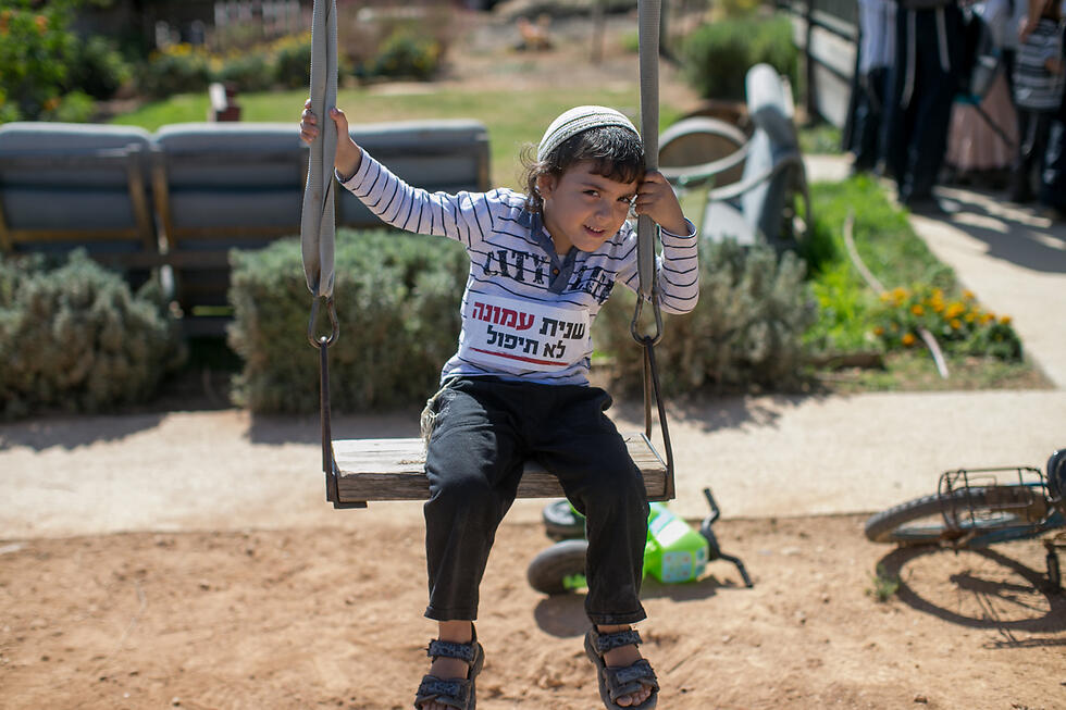 A child in Amona with a sticker on his shirt saying: 'Amona will not fall again' (Photo: Ohad Zwigenberg)