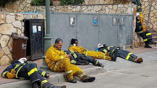 Firefighters resting in Zikhron after battling the flames throughout the night (Photo: Ahiya Raved (צילום: אחיה ראב"ד) Firefighters resting in Zikhron after battling the flames throughout the night (Photo: Ahiya Raved