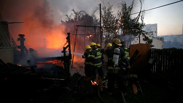 Firefighters battling the flames in Haifa on Thursday (Photo: Reuters)