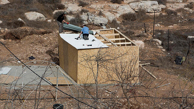 Settlers building a wooden house in Amona (Photo: AFP)