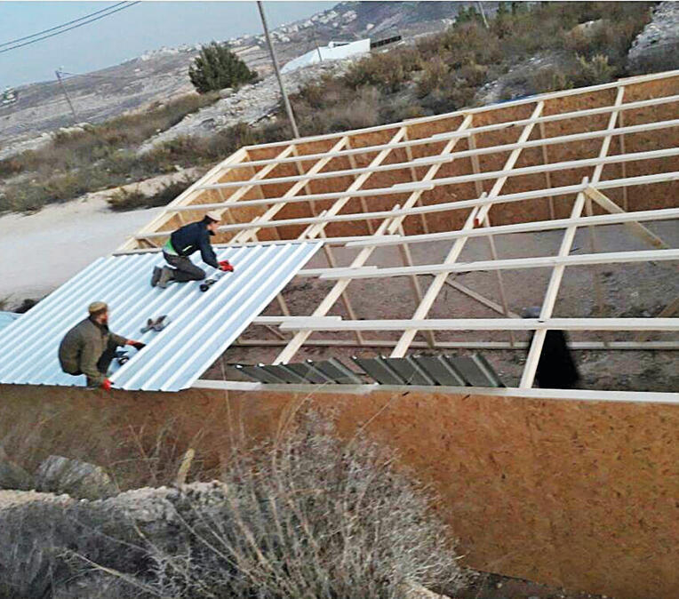 Volunteers building temporary structures in Amona