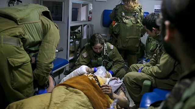 IDF medical personnel treat a wounded Syrian in an ambulance on the Israel-Syria border (Photo: Reuters) (Reuters) IDF medical personnel treat a wounded Syrian in an ambulance on the Israel-Syria border (Photo: Reuters)
