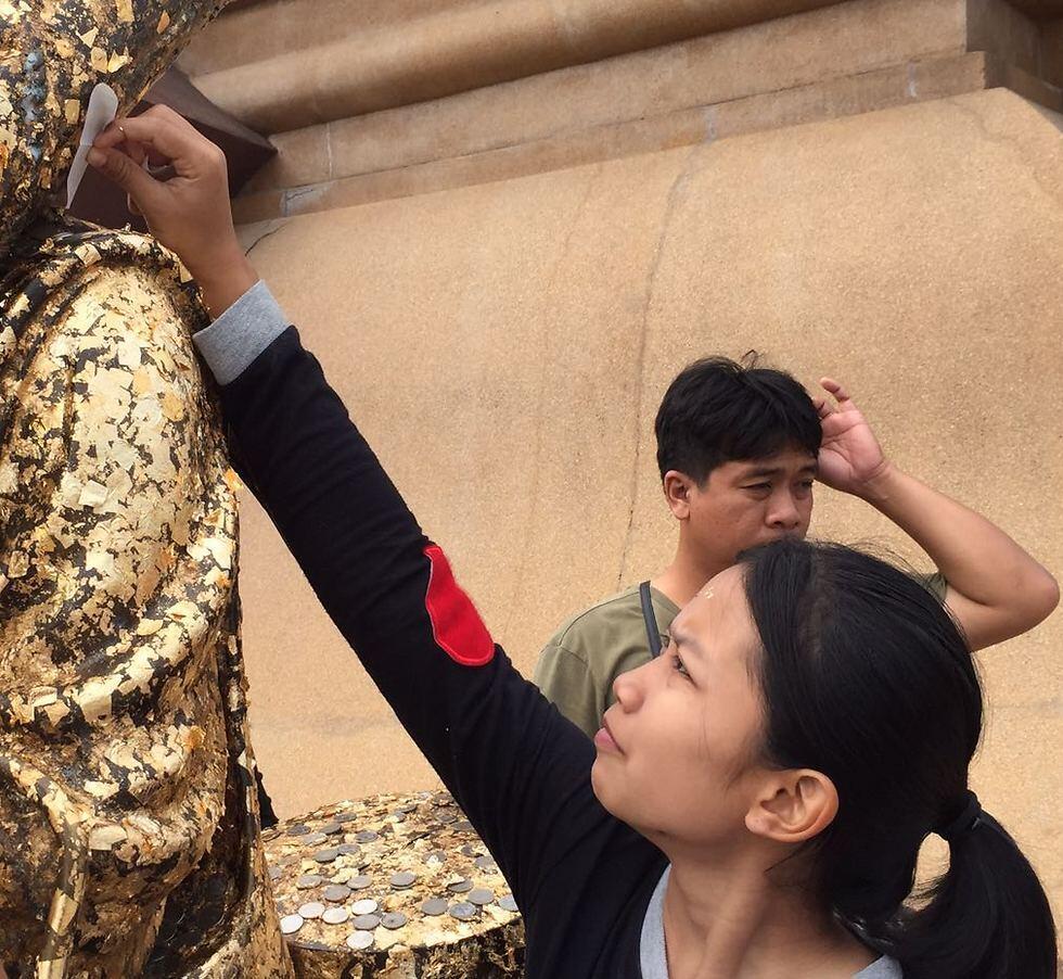 Thai people pray at Buddhist monk's statue by writing their requests on a note and rubbing it on statues of monks (Photo: Gaby Zohar) 