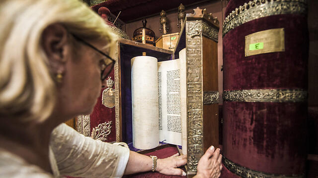 The president of the Egyptian Jewish Community, Magda Shehata Haroun, before Torah scrolls (Photo: AFP)
