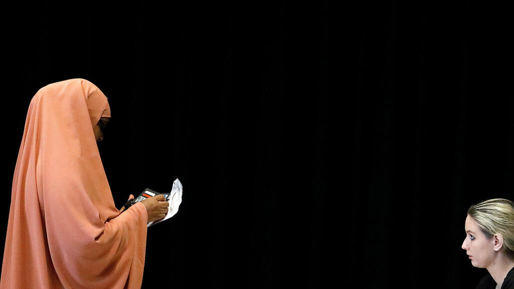 A Muslim woman casts her vote during the Dutch elections 