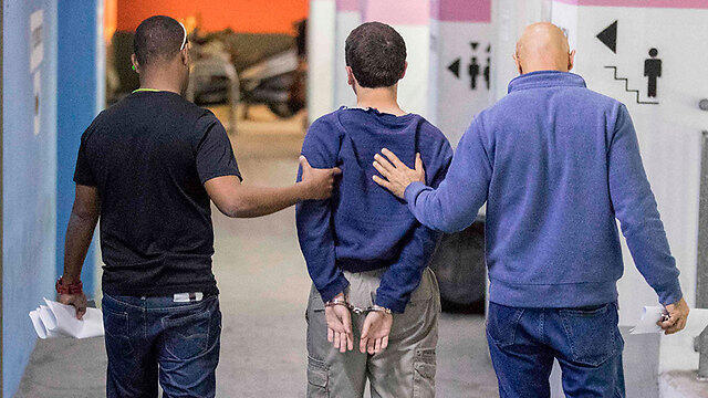 The defendant, in the middle, being carried away after a court hearing