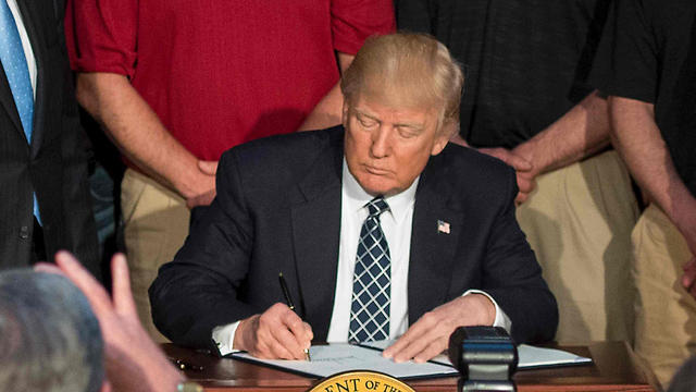 President Trump signs executive order (Photo: AFP)