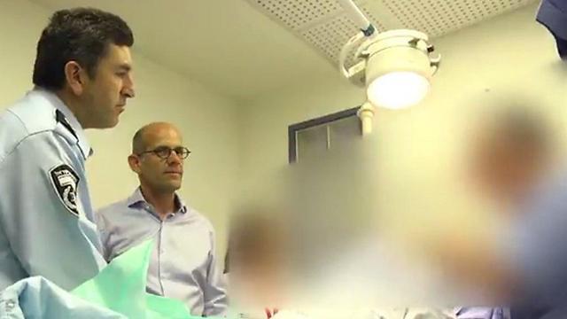 Yoram Halevy (L) visits N. in the hospital. (Credit: Israel Police)