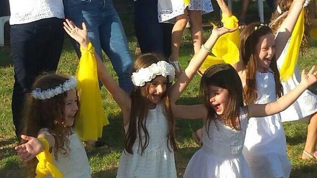 Girls in Balfuria raise their arms skyward as the sun sets upon Moshav Balfuria (Photo: Jezreel Valley Regional Council's Spokesperson's Office): 