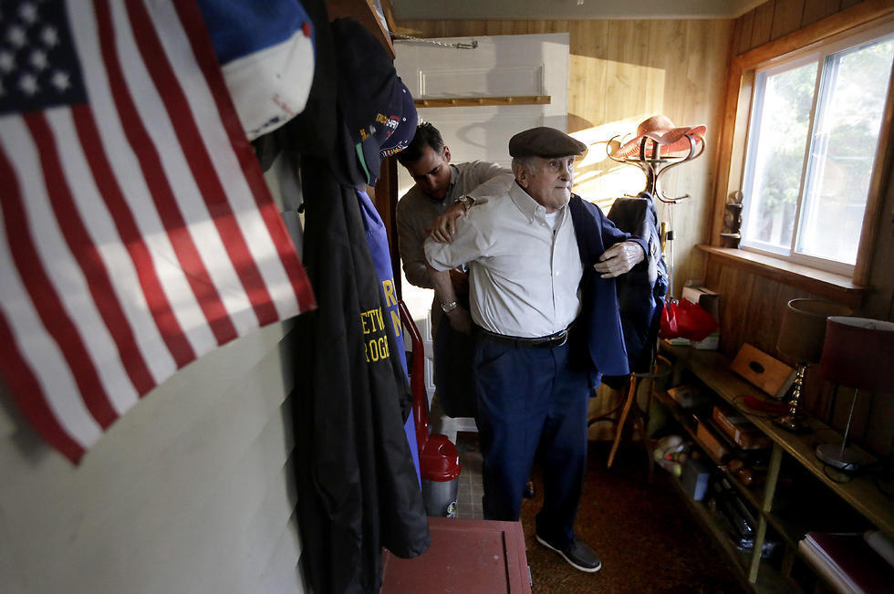  Holocaust survivor Steve Ross, right, is helped with his jacket by his son Mike Ross, behind, as they prepare to depart Steven Ross' home in Newton, Mass., to attend the premier of the film "Etched in Glass: The Legacy of Steve Ross." (Photo: AP)