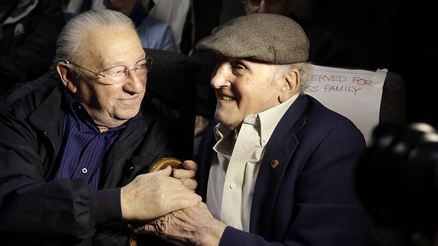 Holocaust survivors Israel Arbeiter, left, and Steve Ross, right, greet one another at a theater before the premier of the film "Etched in Glass: The Legacy of Steve Ross," in West Newton, Mass. (Photo: AP)