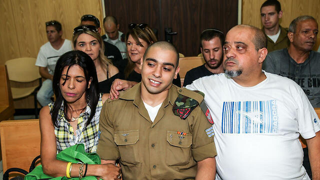Azaria during his trial with his father Charlie and mother Oshra