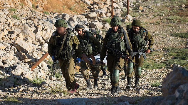 A wounded Syrian is carried by IDF troops to treatment (Photo: IDF Spokesperson's Unit) (צילום: דובר צה"ל) A wounded Syrian is carried by IDF troops to treatment (Photo: IDF Spokesperson's Unit)