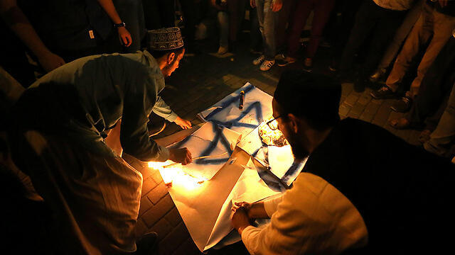 Protestors burn flag (צילום: EPA) Protestors burn flag