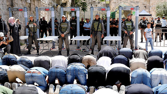 Palestinians praying outside Temple Mount in protest against new security measures (Photo: EPA)