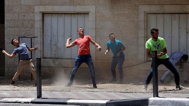 Palestinian youths throwing rocks at security forces (Photo: Reuters)