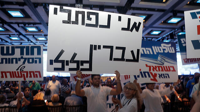 Netanyahu supporters at Wednesday's rally, with a sign that reads, 'Meni Naftali is a criminal' (Photo: Shaul Golan)