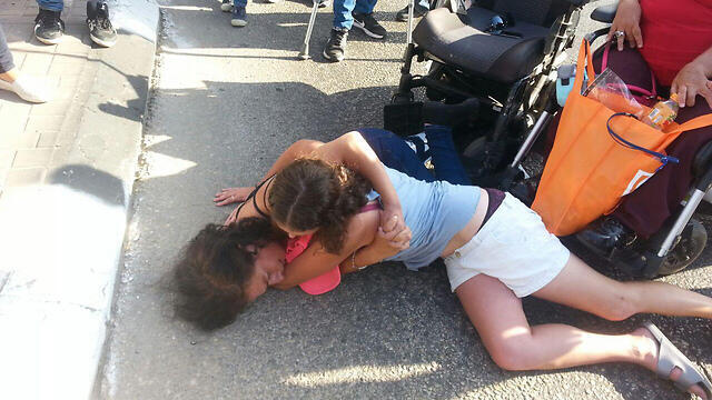 Cuffed protestor lying on ground and covered by friend (Photo: Amir Alon) (צילום: אמיר אלון) Cuffed protestor lying on ground and covered by friend (Photo: Amir Alon)