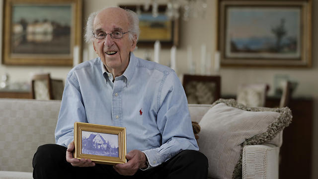 Peter Hirschmann, holding a picture of his family's home (Photo: AP) Peter Hirschmann, holding a picture of his family's home