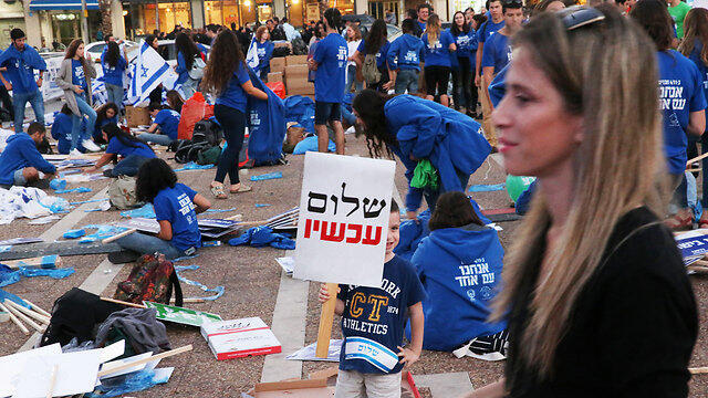Preparations for the rally, including sign say: 'Peace now'