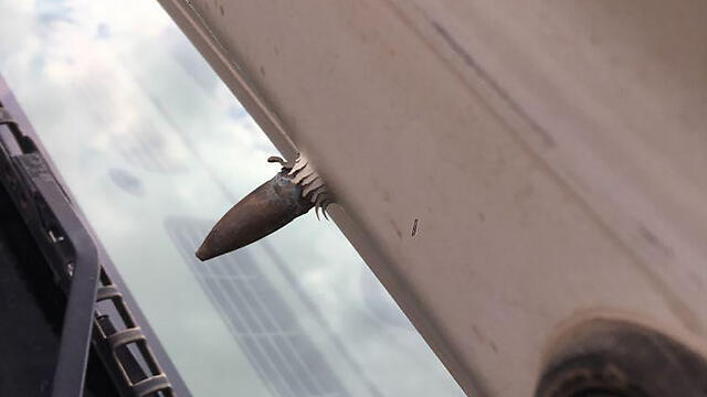 The bullet, still lodged in the hood of Azoulay's car