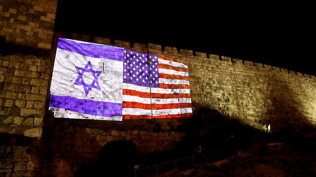 The walls of the Old City illuminated with the American and Israeli flags