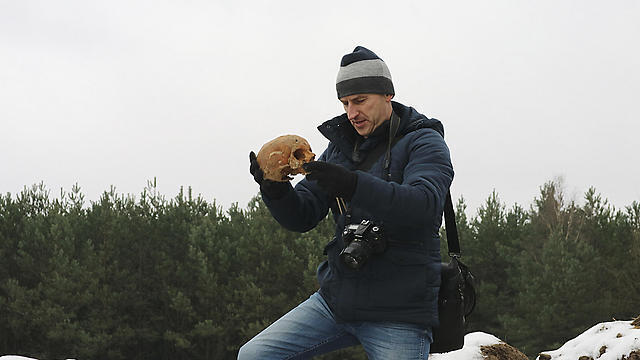 Man holding human remains removed from an old Jewish cemetery and dumped in huge mounds in Siemiatycze, Poland to make way for the construction of a supermarket, parking lot and an electrical transformer station