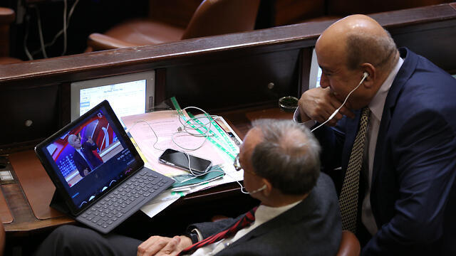 MKs Nachman Shai and Zouheir Bahloul watching TV satire show Eretz Nehederet during discussions on the bill in the Knesset