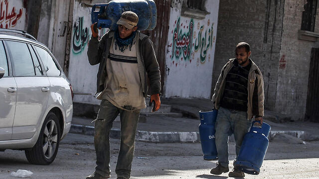 Men in Gaza carrying water home for lack of running water