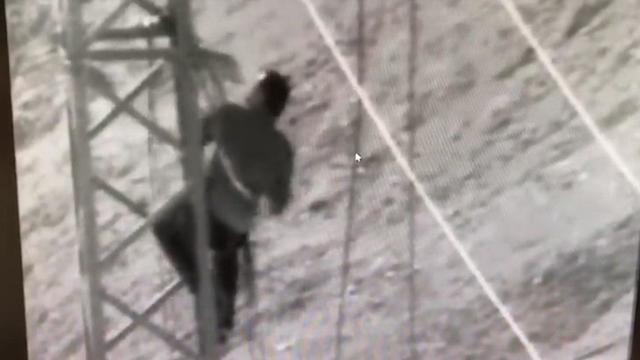 A Hamas operative climbing a high voltage line