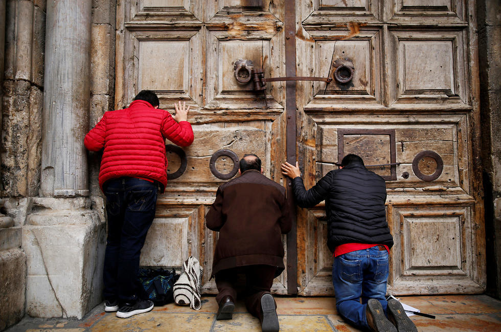 Praying outside the church's closed doors (צילום: רויטרס) Praying outside the church's closed doors
