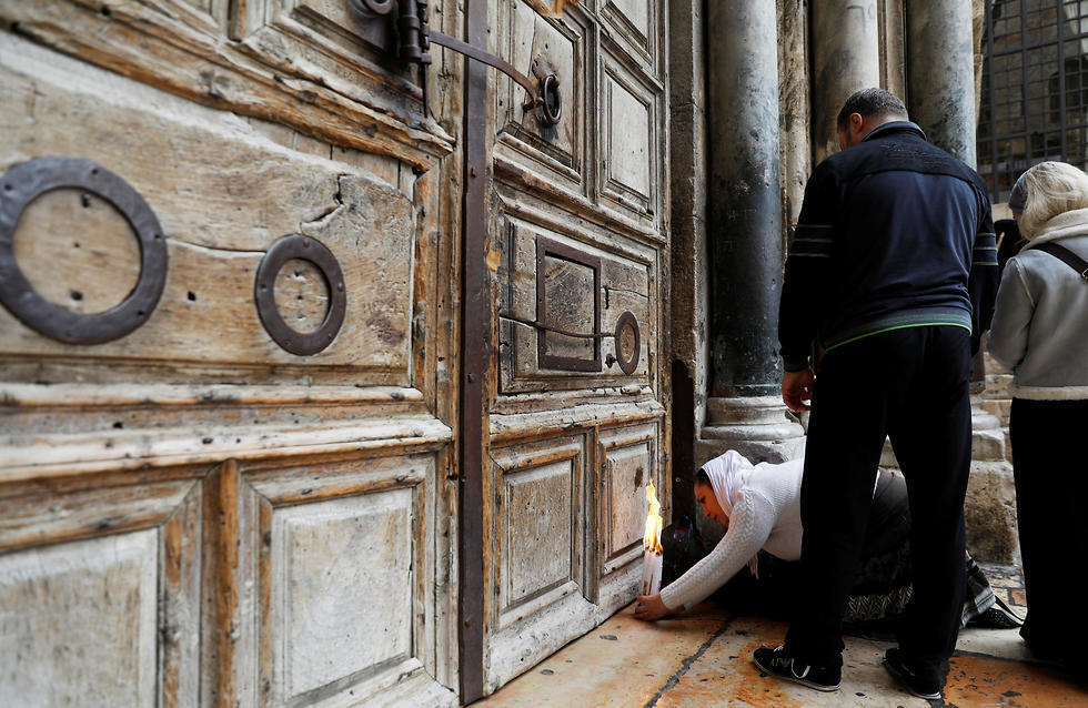 Praying outside the church's closed doors (צילום: רויטרס) Praying outside the church's closed doors