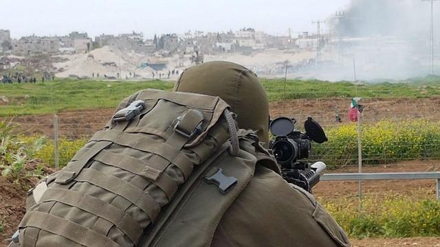 IDF sniper watches as Palestinian protestors riot on Gaza border
