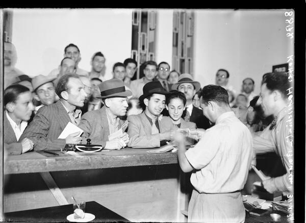 Residents donate money and jewelry at an Anglo-Palestine Bank branch in Tel Aviv for a fundraising drive organized by the Jewish National Council, 1938 (Photo: State Archives) אזרחים תורמים כסף ותכשיטים בסניף בנק אנגלו-פלשתינה בתל-אביב, למען המגבית שארגן הוועד הלאומי, 1938
