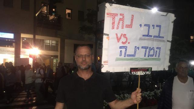 Citizen holds sign saying 'Bibi Vs. the state.' (צילום: רועי רובינשטיין) Citizen holds sign saying 'Bibi Vs. the state.'