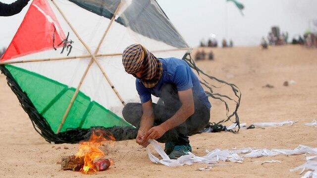 Palestinian rioter prepares incendiary kite on Gaza border