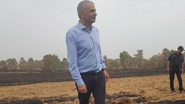 Treasury Minister Kahlon during a tour of a burned field in the Be'eri kibbutz