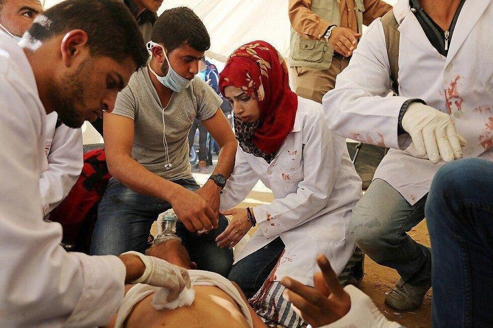 Najjar treating a wounded man at the Gaza Strip border