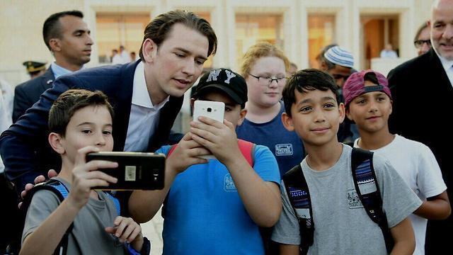 Kurz poses for selfie with children at the Western Wall 