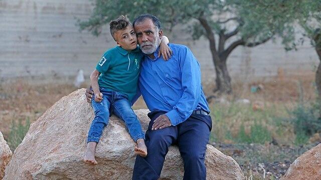 Hussein Dawabsheh with his grandson Ahmed, the only one to survive the attack (צילום: שאול גולן) Hussein Dawabsheh with his grandson Ahmed, the only one to survive the attack