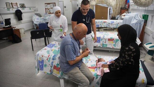 An Israeli doctor treats a Syrian baby (Photo: Reuters) An Israeli doctor treats a Syrian baby