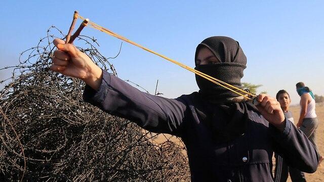 Palestinian protester launches stones at IDF soldiers